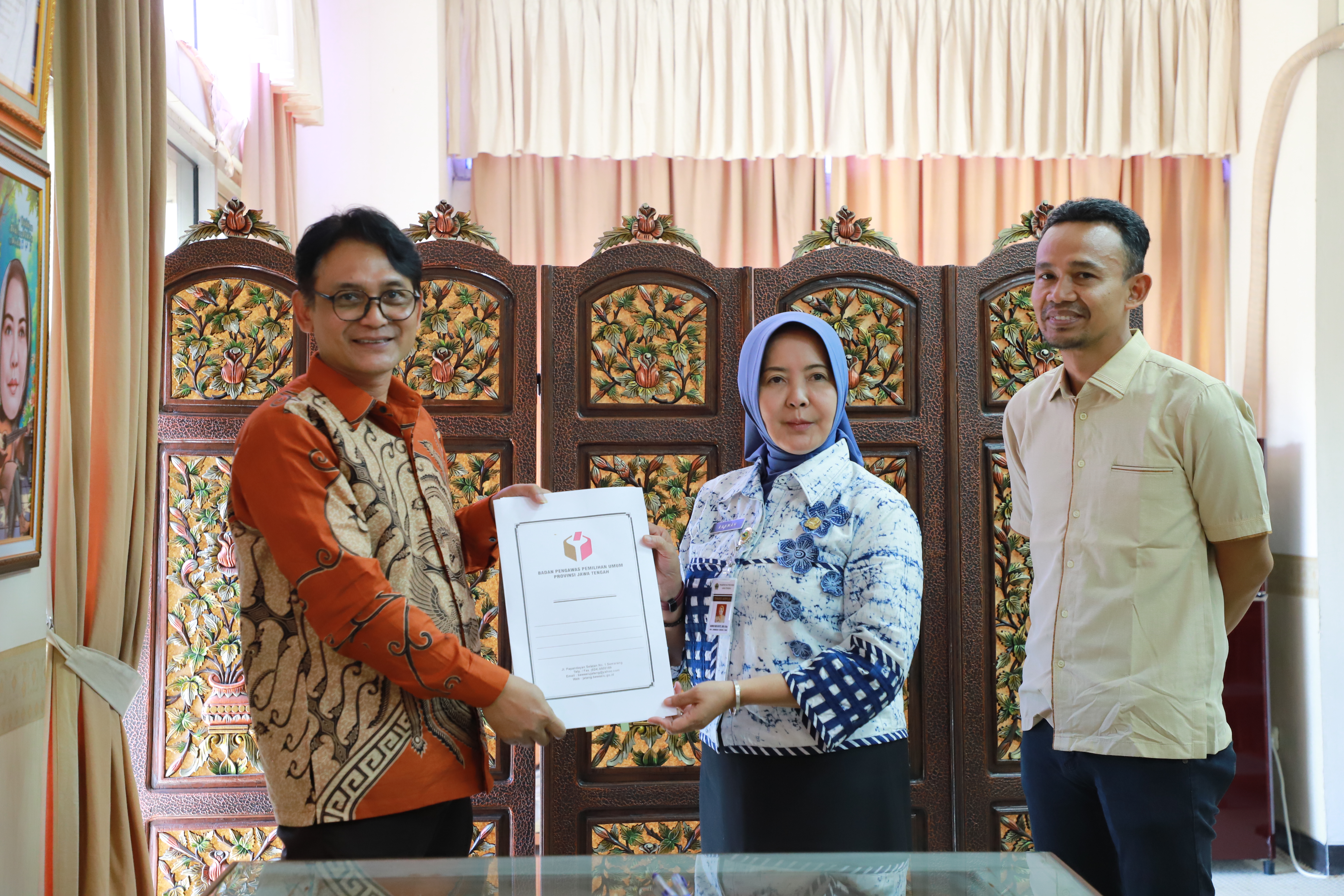 Muhammad Amin menyerahkan MoU yang telah ditandatangani kepada Kepala Arpusda Ibu Rahmah Nur Hayati
